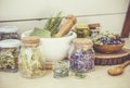 Lot of different dry herbal remedy plants in glass containers.