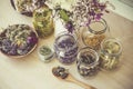 Lot of different dry herbal remedy plants in glass containers.