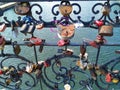 A lot of different locks on the forged fence of the bridge. As a symbol of strong love at a wedding. On the background of water, g