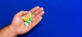 A lot of different pills in a male hand close-up. Blue blurred background. Pharmaceutical business concept. Healthcare industry.