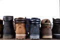 A lot of different shoes stand flush, the reverse side, in a row on a wooden board, concept, assortment of boots