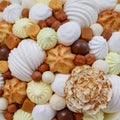 A lot of different sweets, such as: marshmallows, sweets, chocolate, biscuits and meringue in the form of carnation as a backgroun