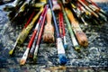 A lot dirty artist paint brushes in a bucket