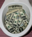 A lot of dollars in a toilet bowl. Money toilet Royalty Free Stock Photo