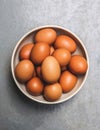 Fresh and raw eggs in white bowl on plain background