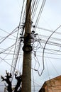 A lot of electrical cable on the electricity post. Blue sky background. Wire and cable clutter. Chaotic wire on the pole. Royalty Free Stock Photo