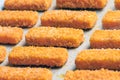 A lot of fish sticks ready for frying on special paper. Cooking concept for frying fish fingers in the oven. Side view Royalty Free Stock Photo