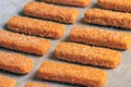 A lot of fish sticks ready for frying on special paper. Cooking concept for frying fish fingers in the oven. Side view. Royalty Free Stock Photo