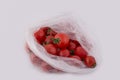 A lot of fresh cherry tomatoes in a package isolated on white background. One is cut in half. Royalty Free Stock Photo