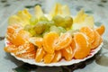 A lot of fruit on a plate. Apple, tangerine, grapes