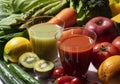 A lot of fruits and vegetables on a white background with a glass of green smoothie and vegetable juice