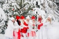 A lot of girls open a bottle of champagne violently in the winter new year`s forest.Girls in red and white clothes with new year Royalty Free Stock Photo