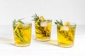 A lot of glasses of lemonade with cold tea and rosemary
