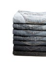 Lot of grey used jeans stacked in a pile isolated on white Royalty Free Stock Photo