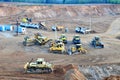 A lot of heavy construction equipment in the mining quarry. Parking with bulldozers, tractors, front loaders, excavators and dump Royalty Free Stock Photo