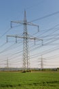 A lot of high-voltage power line, transmission tower overhead line masts, high voltage pylons also known as power pylons on the fi Royalty Free Stock Photo