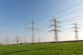 A lot of high-voltage power line, transmission tower overhead line masts, high voltage pylons also known as power pylons on the fi Royalty Free Stock Photo