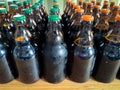 A lot of home brewery self made beer. Many brown glass craft beer bottles with green and orange corks, close up front view on a Royalty Free Stock Photo