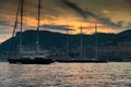 A lot of huge sail yachts and motor boats in port of Monaco at sunset, mountains are on background, megayachts are