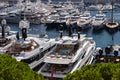 A lot of huge yachts are in port Hercule of Monaco at sunny day, Monte Carlo, many small boats are on background