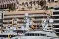 A lot of huge yachts are in port of Monaco at sunny day, Monte Carlo, real estate housing is on background, glossy board