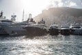 A lot of huge yachts in port of Monaco at sunset, mountain is on background, glossy board of the motor boat, megayachts Royalty Free Stock Photo