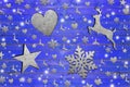 Lot of iron star, heart, dear and snowflake on weathered blue wooden board Royalty Free Stock Photo