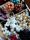 A lot of jewelry for women`s hair from  multicolored beads of pearls. Stylish and fashionable accessories in wooden boxes cells Royalty Free Stock Photo