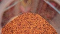 Many small different colors, orange, yellow, brown granules in plastic container