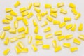 A lot of lying earplugs, for protection against noise in yellow and white, isolated on a white background with a clipping path. Royalty Free Stock Photo
