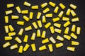 A lot of lying earplugs, for protection against noise in yellow and white, isolated on a black background with a clipping path. Royalty Free Stock Photo