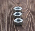 Metal nuts on a wooden background Royalty Free Stock Photo