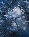 A lot of methane bubbles in the Baikal ice. Cracks on the surface of lake. Winter texture. Royalty Free Stock Photo