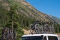 A lot mountain bicycles mounted on roof rack with mountains background. Summer vacation concept