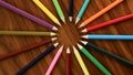 A lot of multicolored pencils revolve in a circle on a black wooden background. Concept office or school, knowledge day, the first