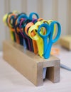 A lot of multicolored scissors in a wooden stand