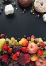 A lot of natural and healthy vitamin fruits, berries vs sweet and junk food on a black background. Vegan eco safe food. The right Royalty Free Stock Photo