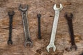 A lot of old wrenches. The working set of wrenches on cracked plywood background Royalty Free Stock Photo