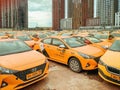 lot of orange city taxi cars with the Yandex Taxi logo on carpark