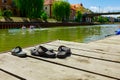 A lot of pairs of slippers on the wooden plank by the river