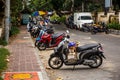 A lot of parked mopeds on an Asian street