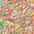 A lot of pastel multi colored vintage plastic buttons randomly scattered on old pink background - top view