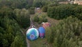 Lot of people looking at how hot air balloons prepare for an summer evening flying in park in small european city