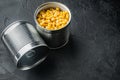 Lot of pieces of canned yellow corn in metall can, on black background with copy space for text