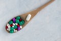 A lot of pills and vitamins in a wooden spoon on a on light background. Royalty Free Stock Photo