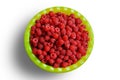 a lot of raspberry in a green dish isolated on white background