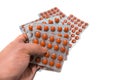 A lot of round tablets in a packs in man`s hand. Pharmaceuticals and pills on a white background Royalty Free Stock Photo
