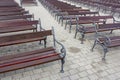 Lot of Rows of empty brown wooden benches