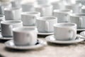 a lot of rows of pure white cups with plates for coffee or tea break Royalty Free Stock Photo