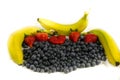 Lot`s of blueberry`s and red strawberry`s with three yellow and green banana`s Royalty Free Stock Photo